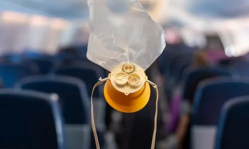 A deployed emergency oxygen mask in a commercial passenger airplane cabin.