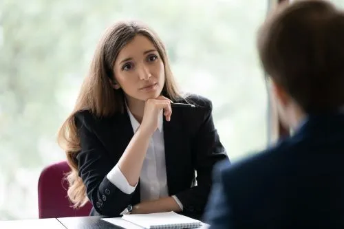 A sympathetic looking sexual abuse lawyer listens to a client tell the details of their case.