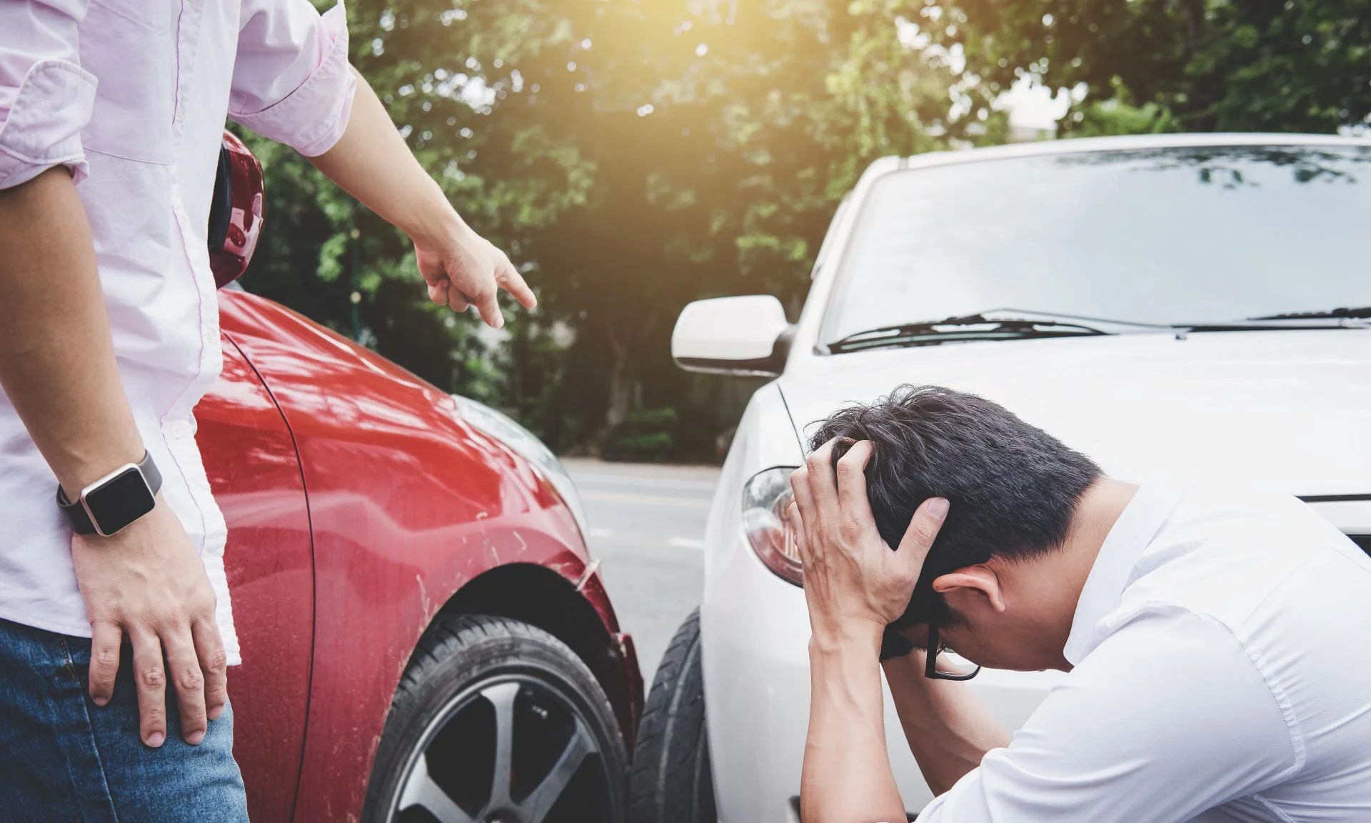 A man yelling at an uninsured driver who caused an accident involving his vehicle.