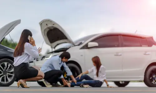 People at an accident scene tending to one victim with a broken leg.