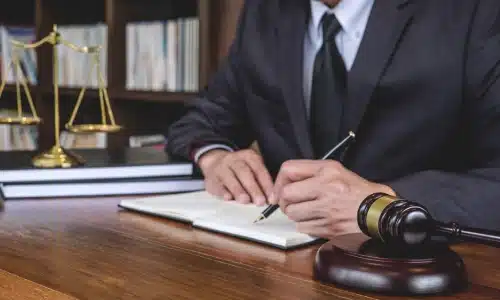 An Illinos personal injury lawyer writes on a notebook placed on his office desk